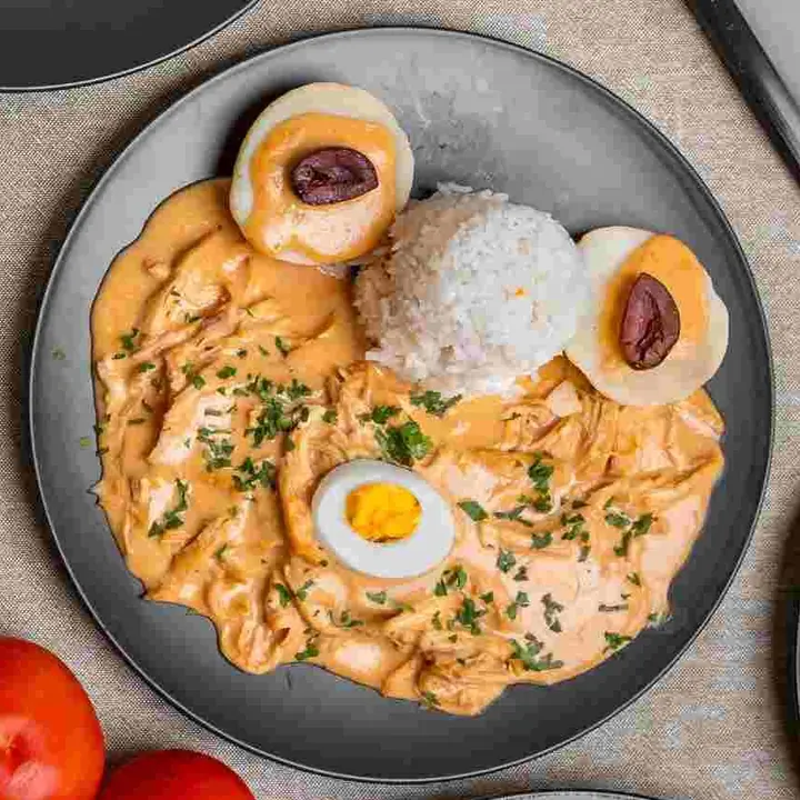 Ají de gallina with rice, boiled egg and olives